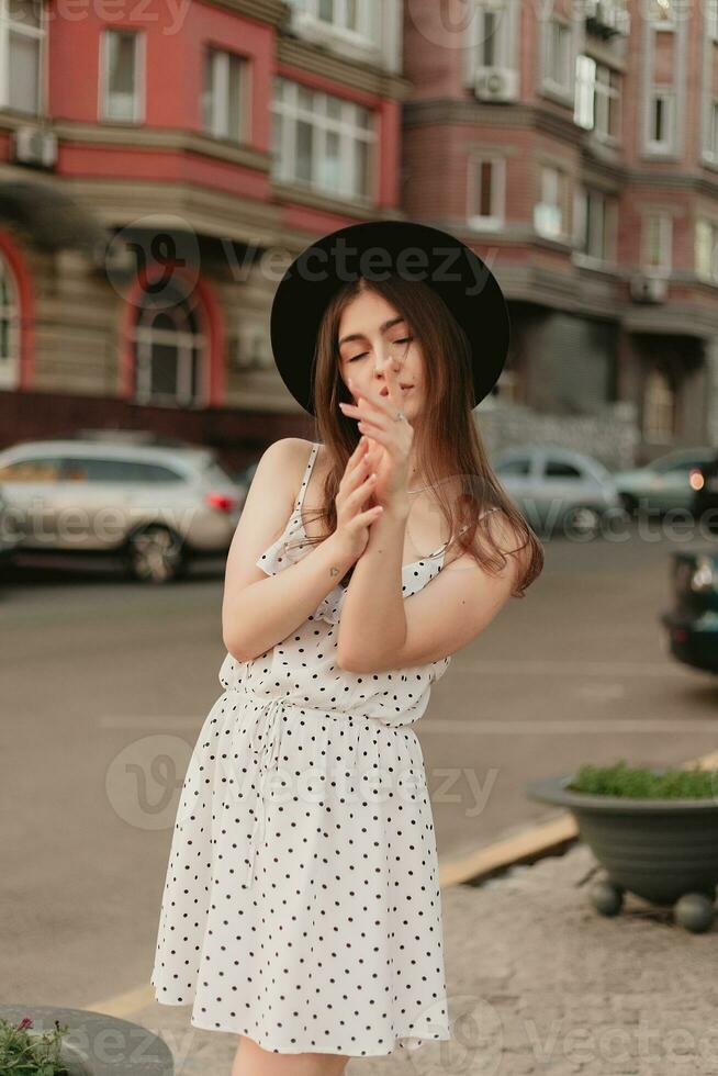 A young teenage girl in a white dress and hat photo