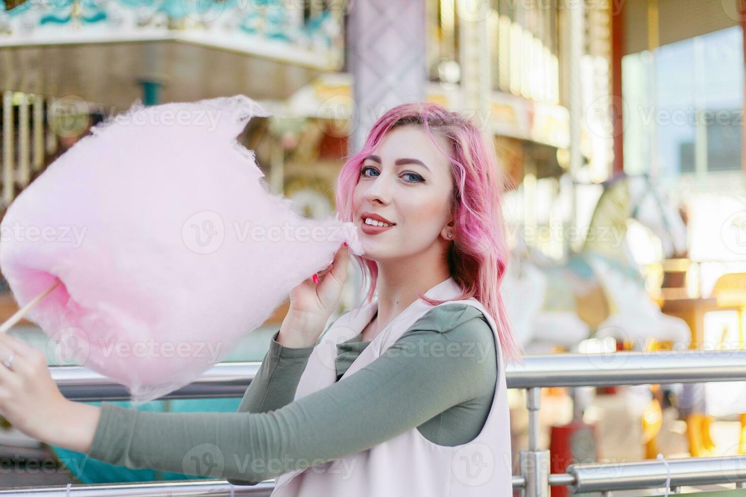 rosado pelo niña corto Corte de pelo posando en diversión parque en carrusel antecedentes. foto