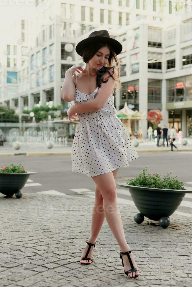 A young teenage girl in a white dress and hat photo