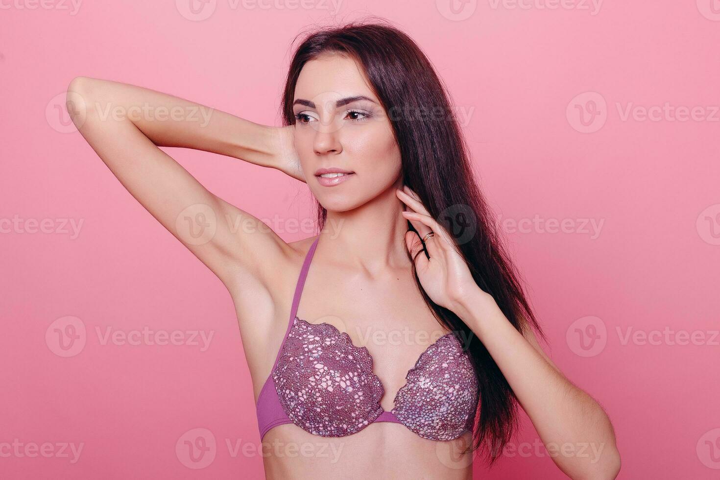 Adorable brunette in bikini posing on pink background photo