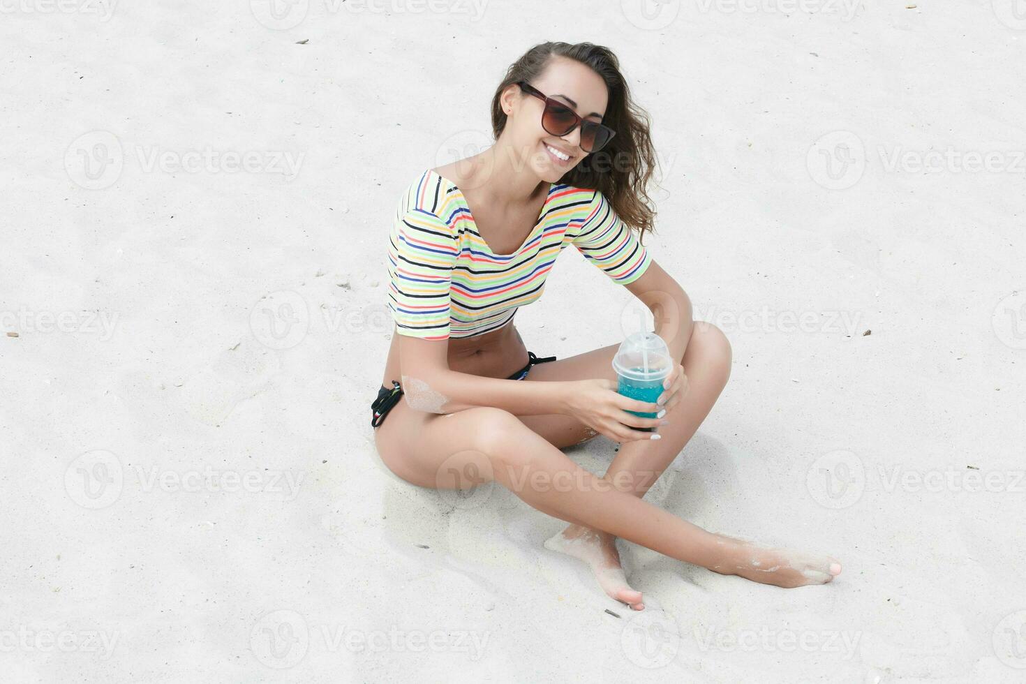 Beach woman drinking cold drink beverage having fun at beach party. photo