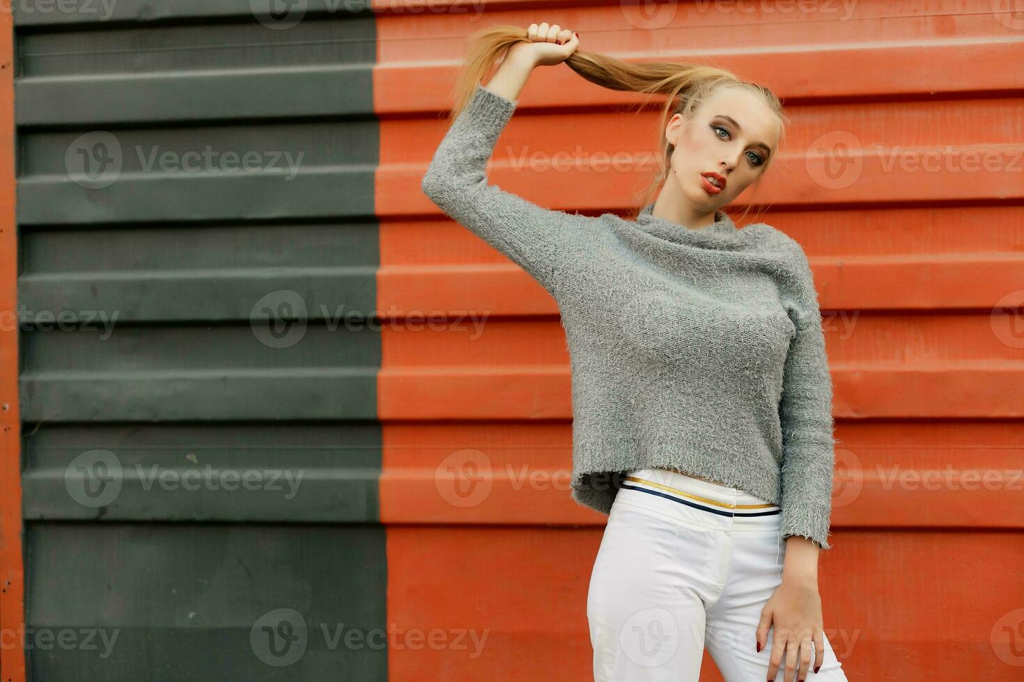 Model pointing upwards in studio and looking at camera photo