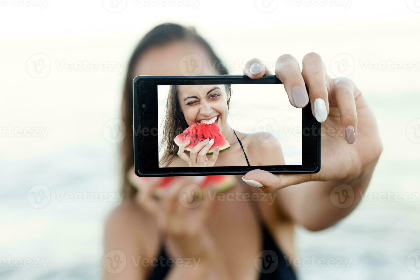 verano vacaciones - joven niña comiendo Fresco sandía en arenoso playa foto