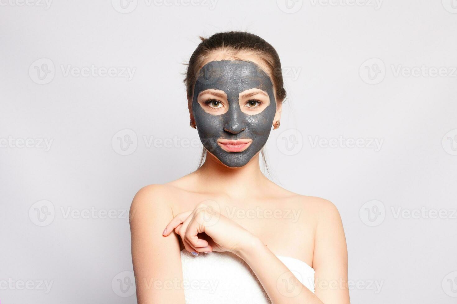 Portrait Of Beautiful Girl Removing Cosmetic Black Peeling Mask photo