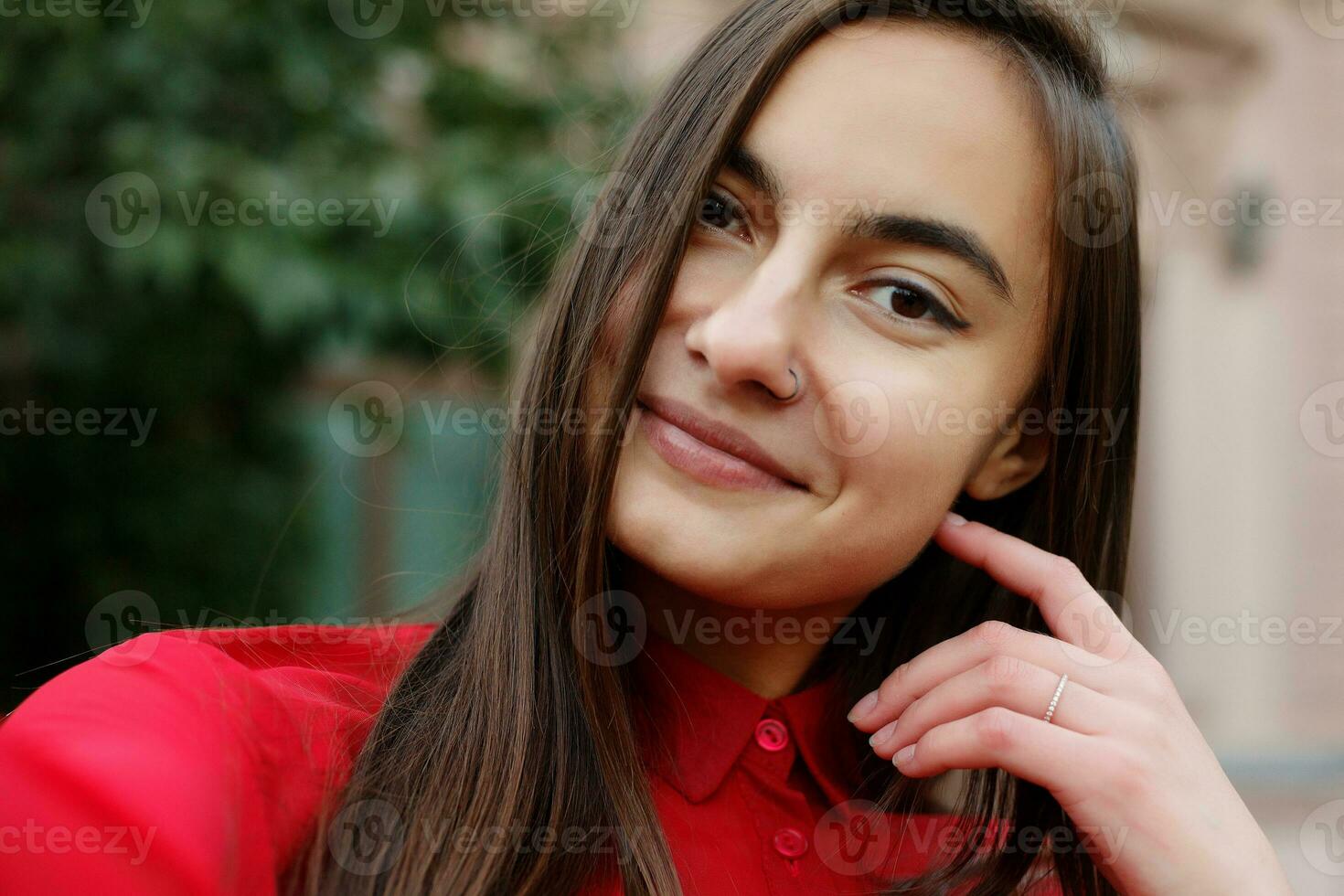 portrait of young attractive female in stylish outfit making selfie photo