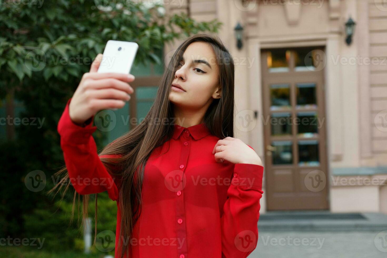 retrato de joven atractivo hembra en elegante atuendo haciendo selfie foto