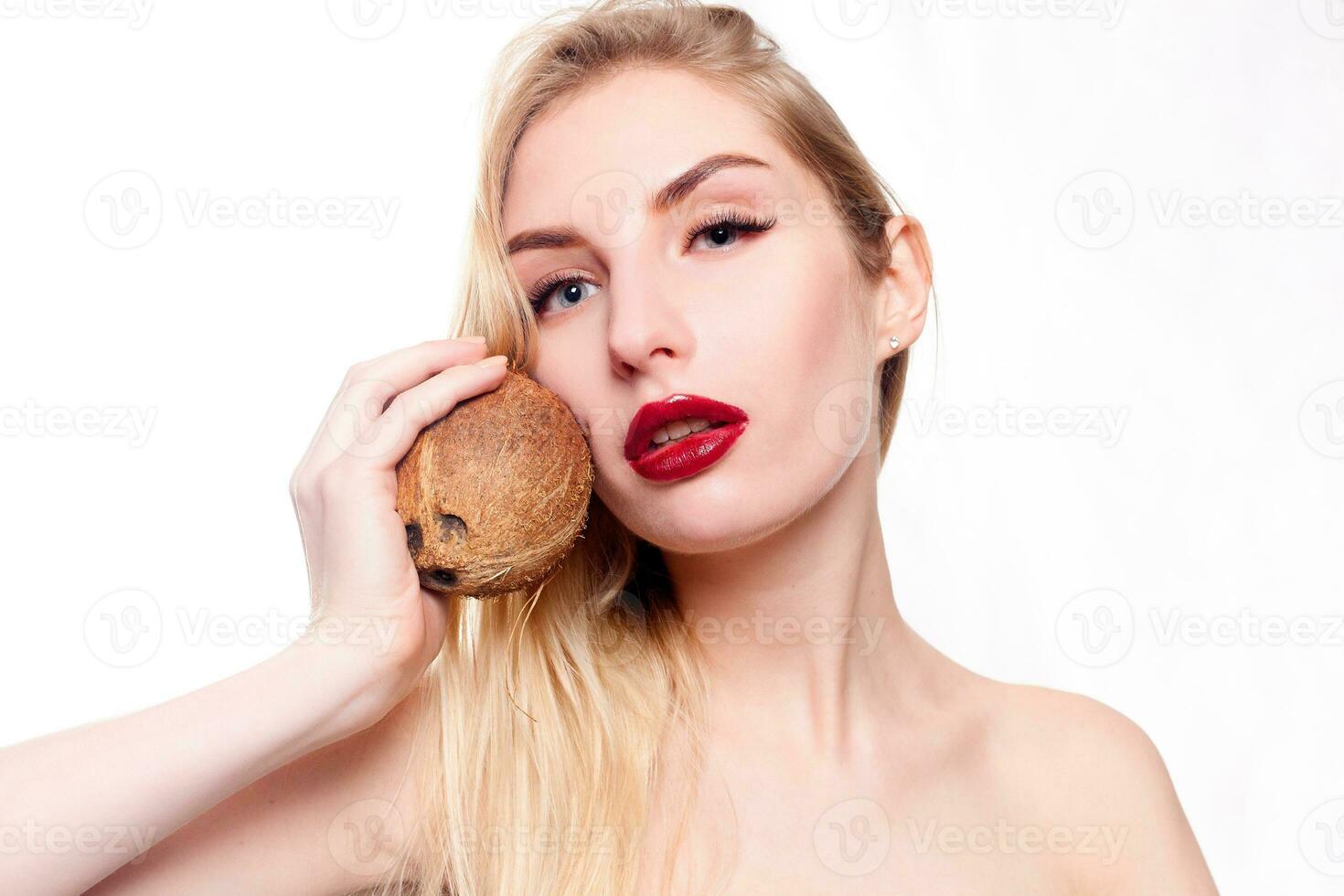 girl with a light natural make-up with coconut in her hand photo