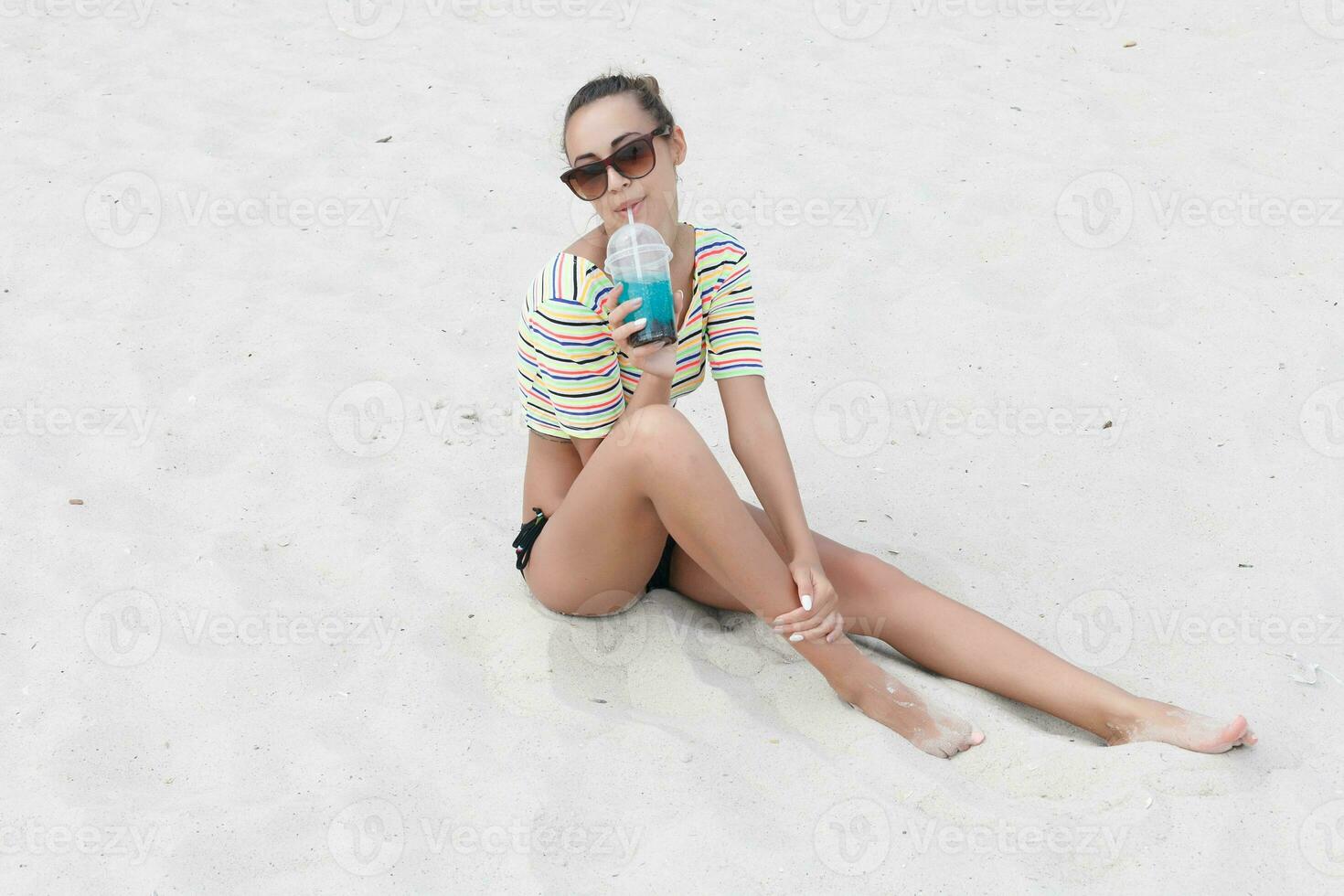 Beach woman drinking cold drink beverage having fun at beach party. photo