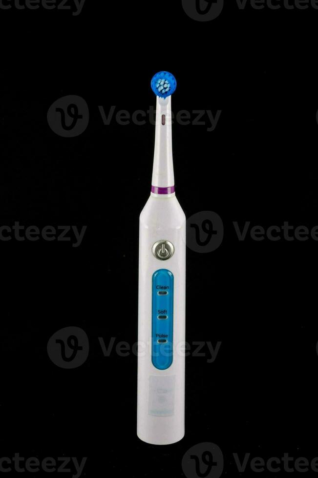 a white electric toothbrush with blue and purple buttons photo
