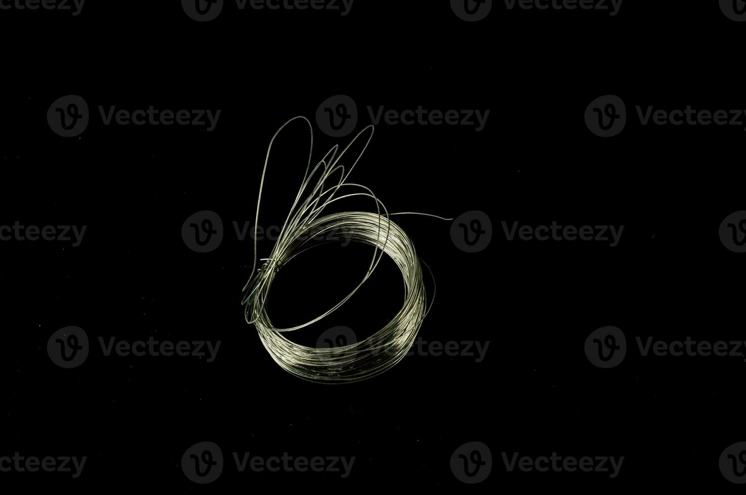 a wire with a loop on it sitting on a black surface photo