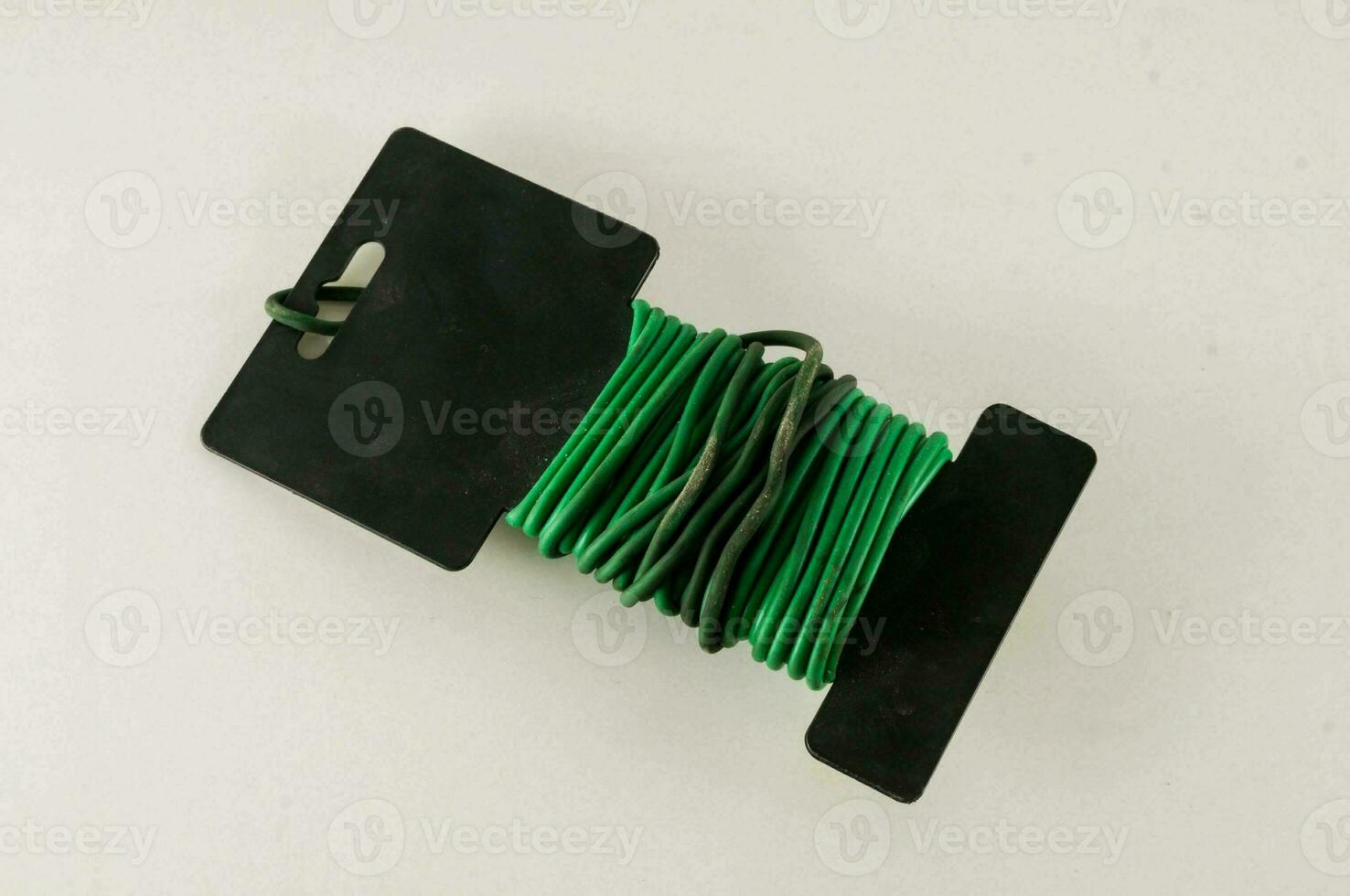 a green wire with black plastic clips on it photo