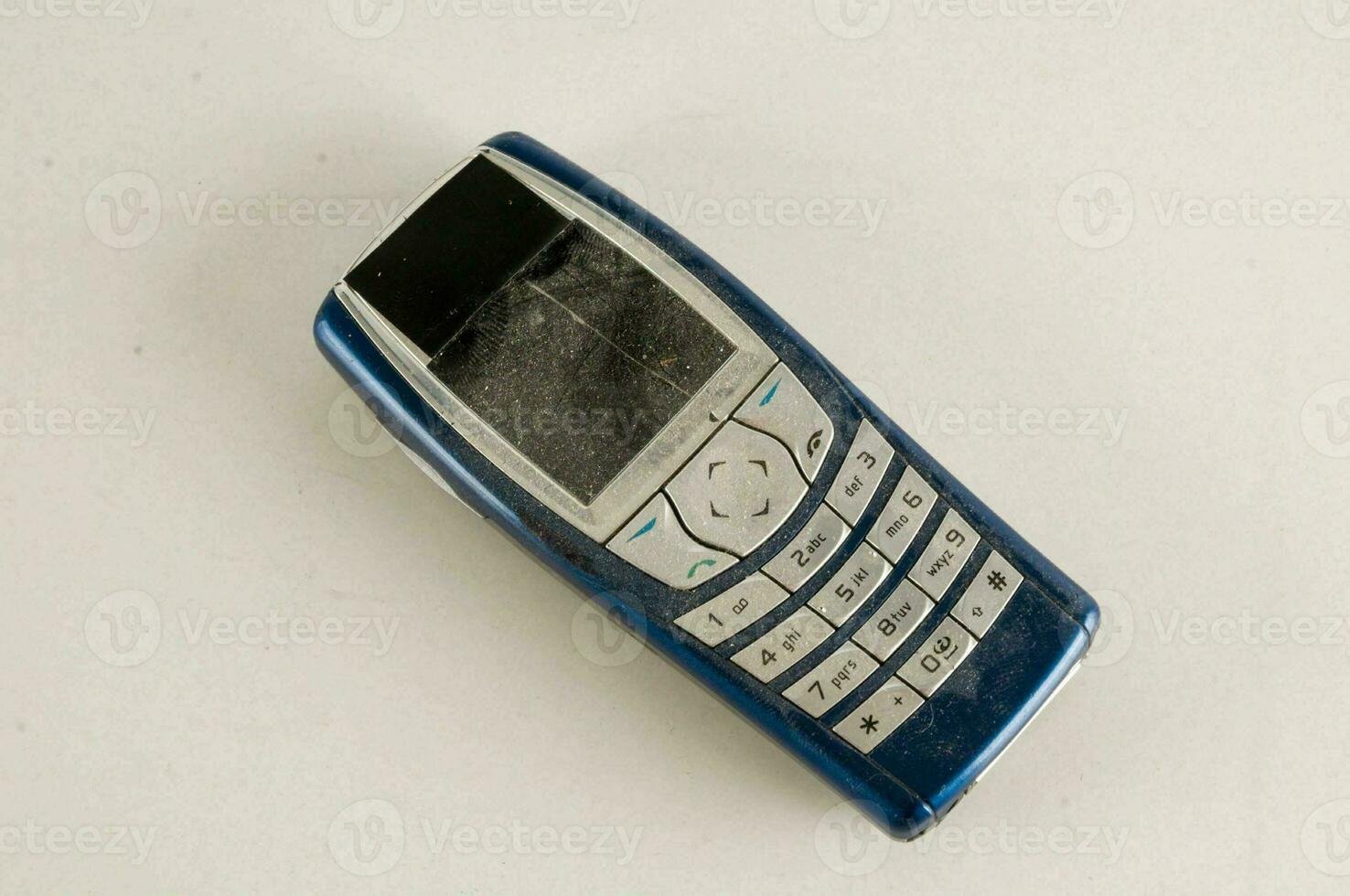 a blue and white cell phone laying on a white surface photo