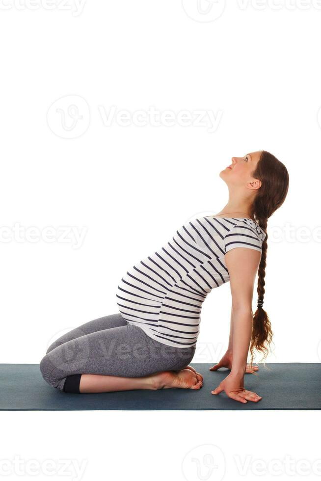 embarazada mujer haciendo yoga asana ustrasana foto