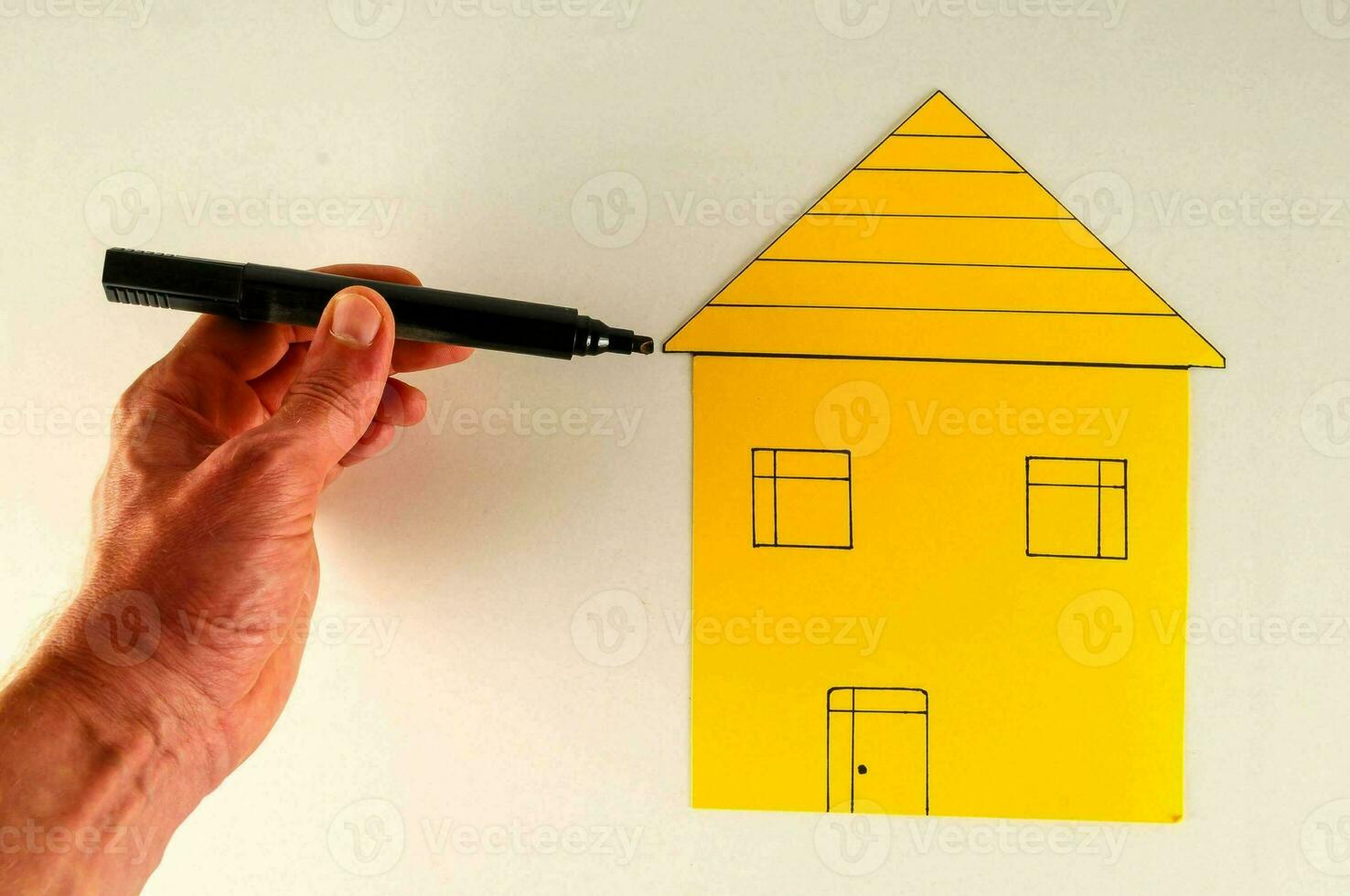 a person is drawing a house on a white board photo
