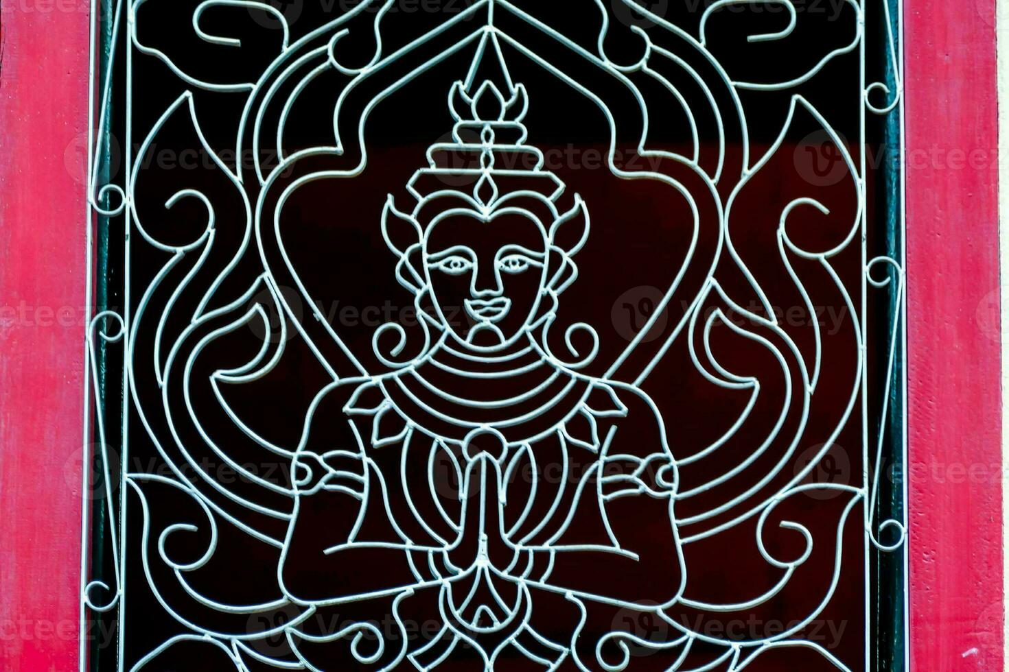 a red and white painted window with a buddha design photo