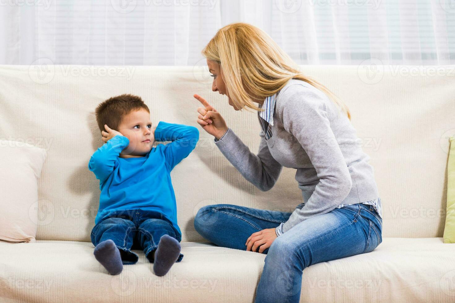 Angry mother is scolding at her son. photo