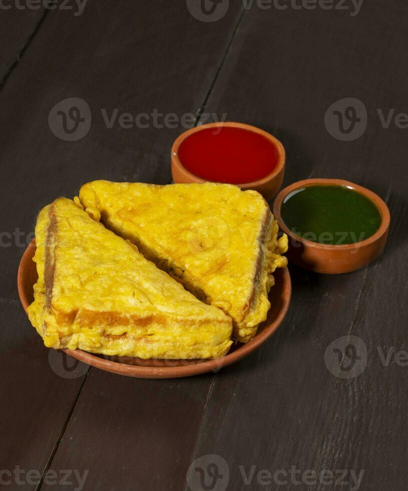 Indian Fried Snack Bread Pakora or Bread Bhaji Served with Tomato Ketchup, Green Chutney it is Made From Bread Slices photo