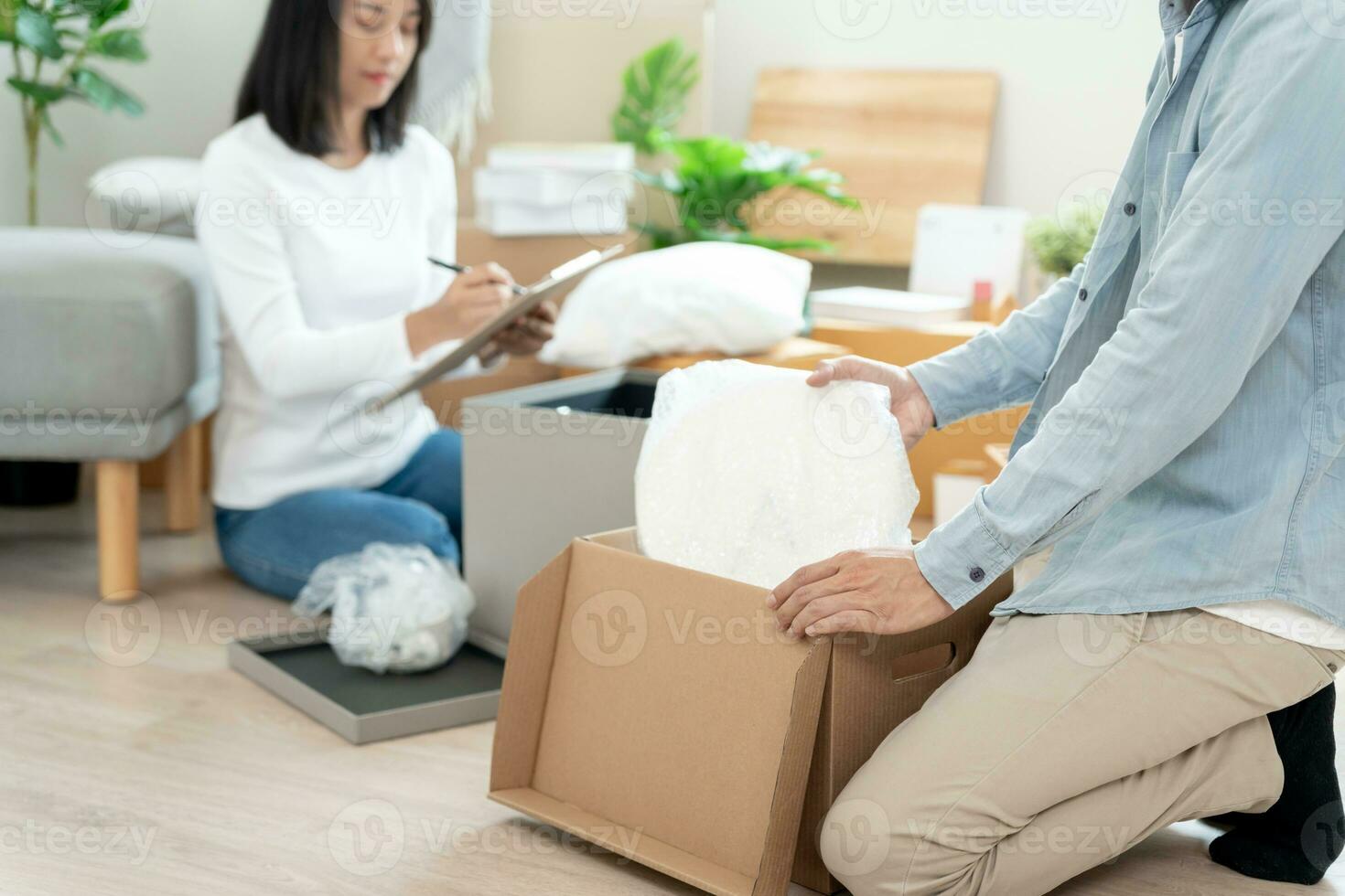 Moving house, relocation. Couple help set and move furniture for new apartment, inside the room was a cardboard box contain personal belongings. move in the new apartment or condominium photo