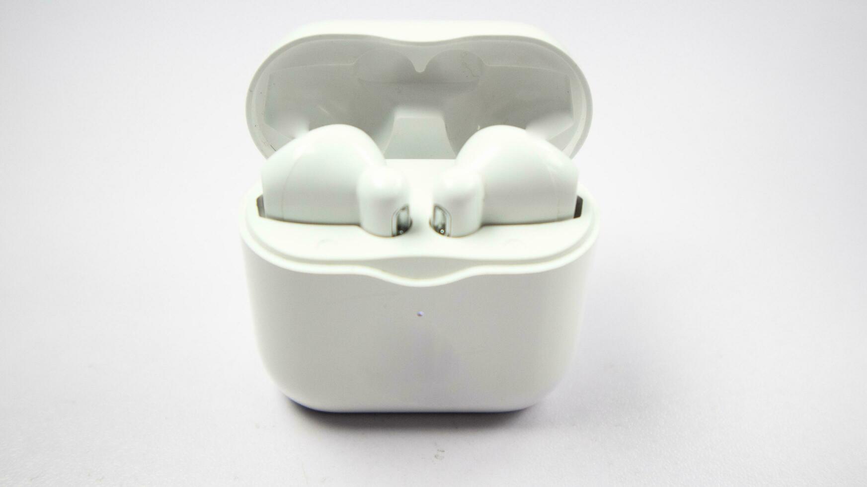 White wireless tws headphones or earbuds and charging case  isolated on white background. photo