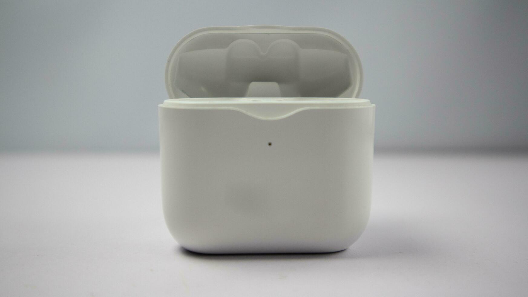 White wireless tws headphones or earbuds and charging case  isolated on white background. photo