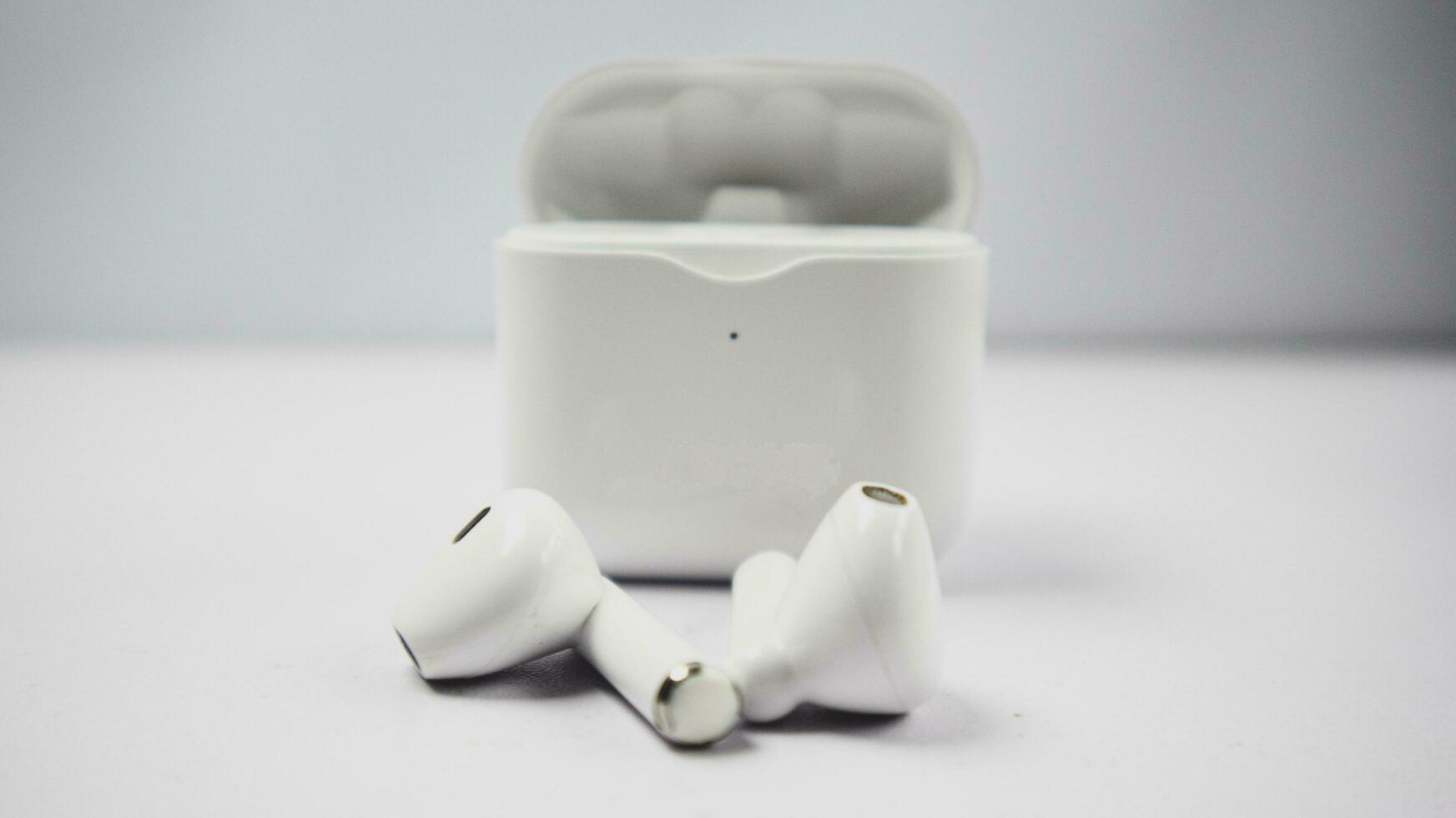 White wireless tws headphones or earbuds and charging case  isolated on white background. photo