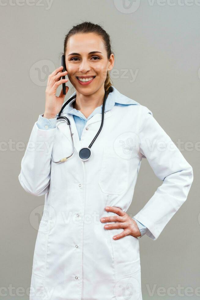 Beautiful female doctor using mobile phone. photo