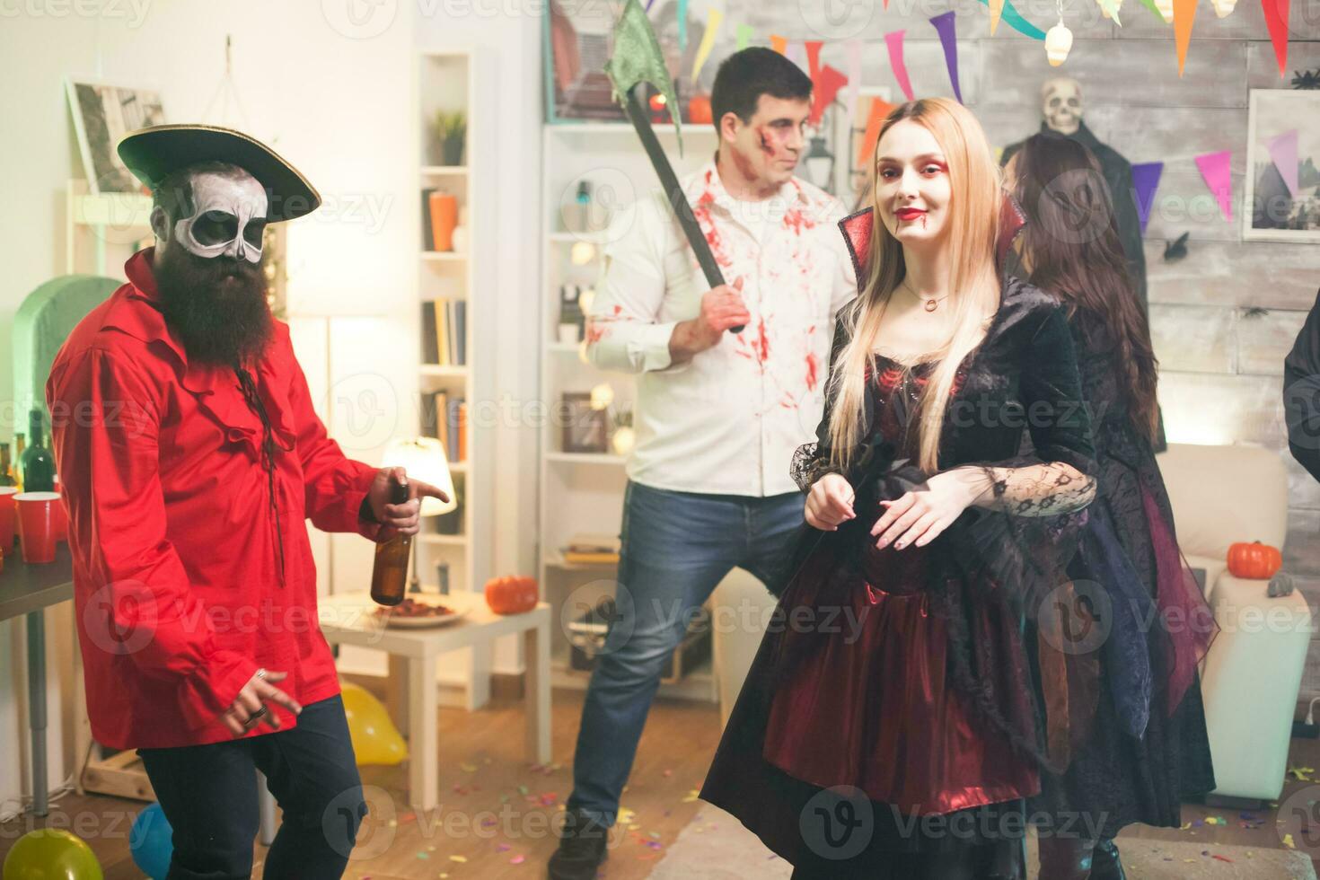 Shy blond woman dressed up like a vampire at halloween party. photo