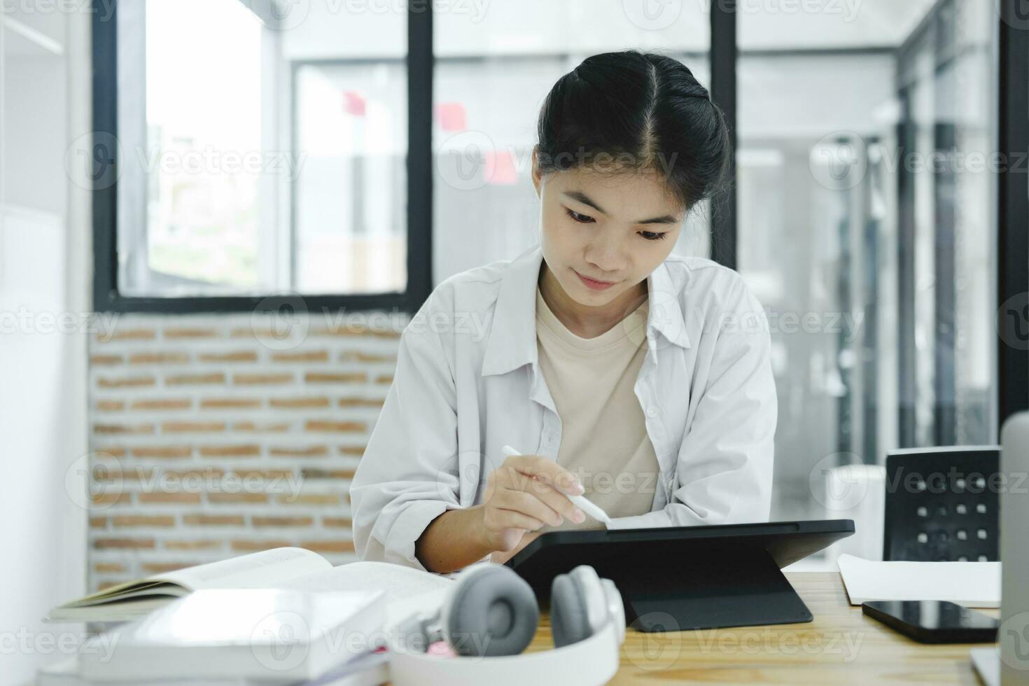 Young collage student using computer and mobile device studying online. photo