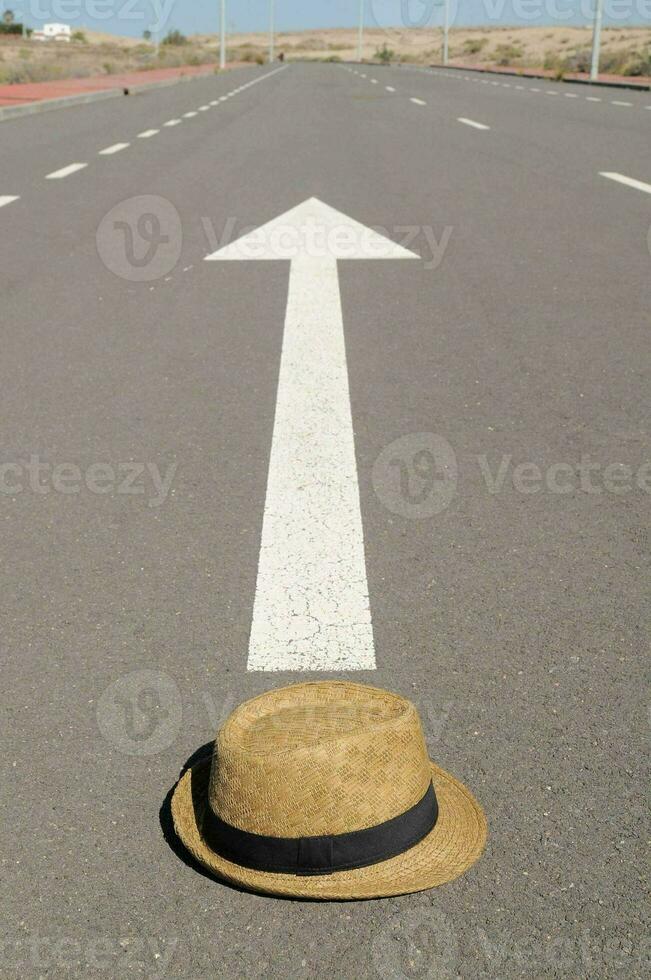 a hat is sitting on the road with an arrow pointing to it photo