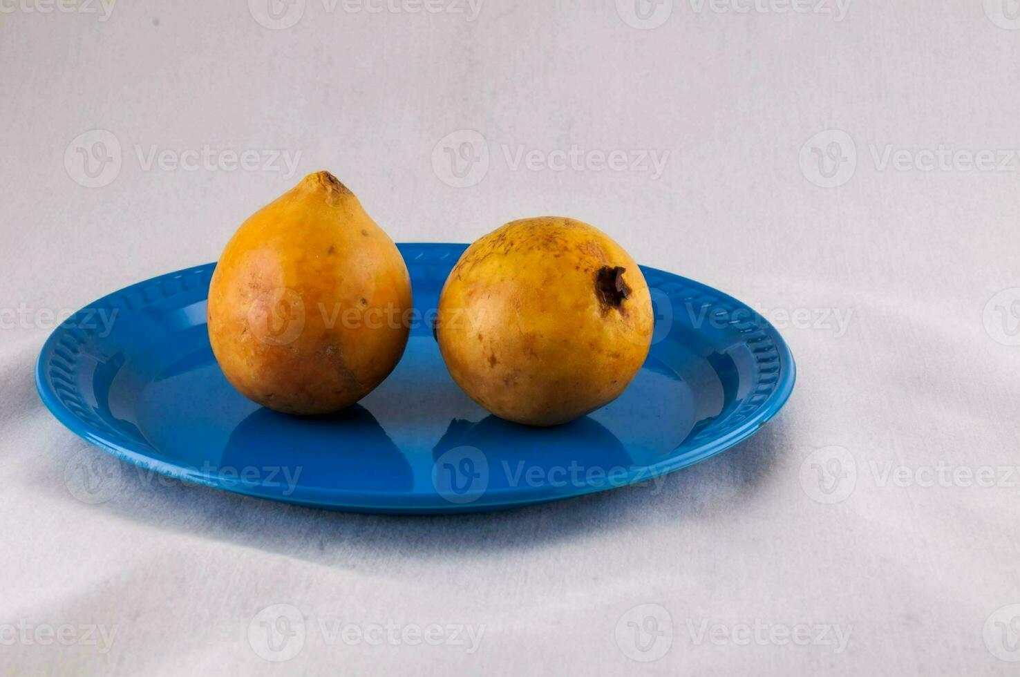 two ripe mangoes on a blue plate photo