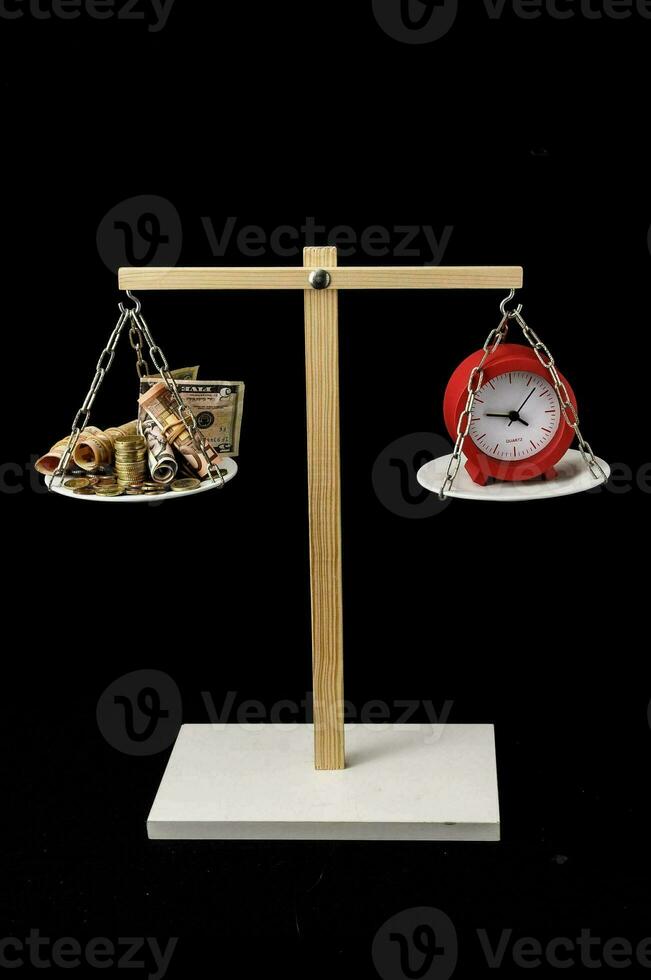 a clock and money on a balance scale photo