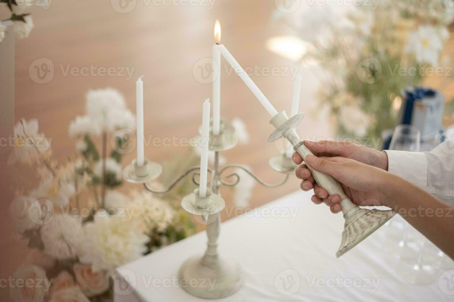 Close up of Bride and groom holding wedding candle during engagement ceremony photo