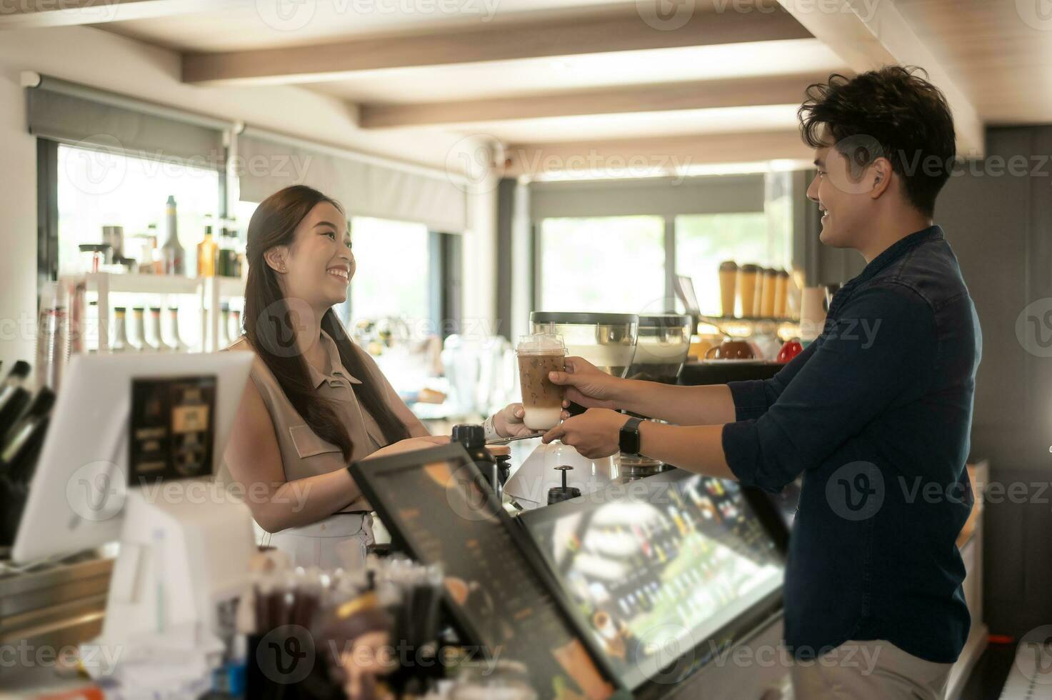 joven asiático Servicio dispuesto barista con cliente en café tienda foto