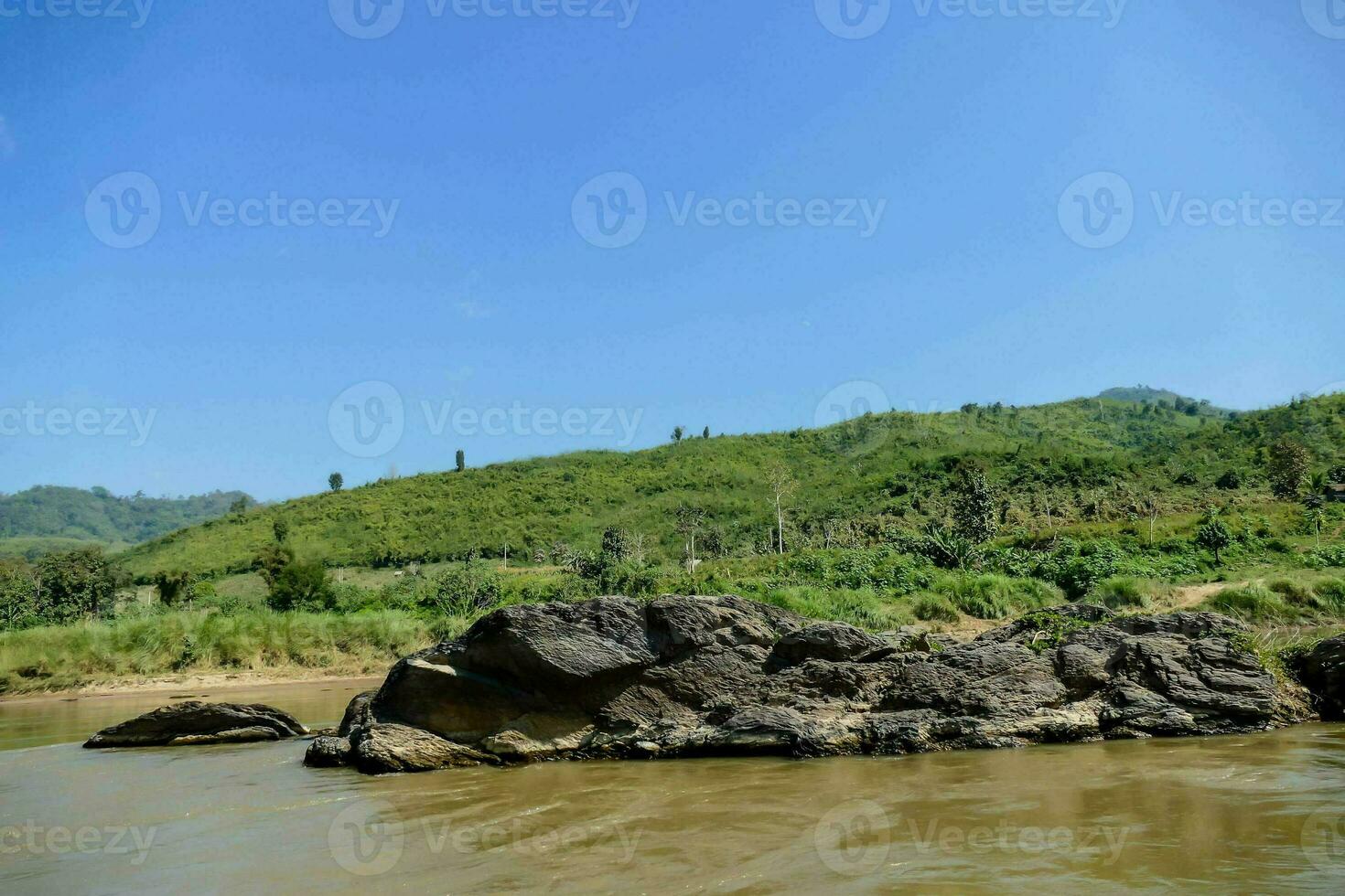 a river with rocks and grass on the shore photo