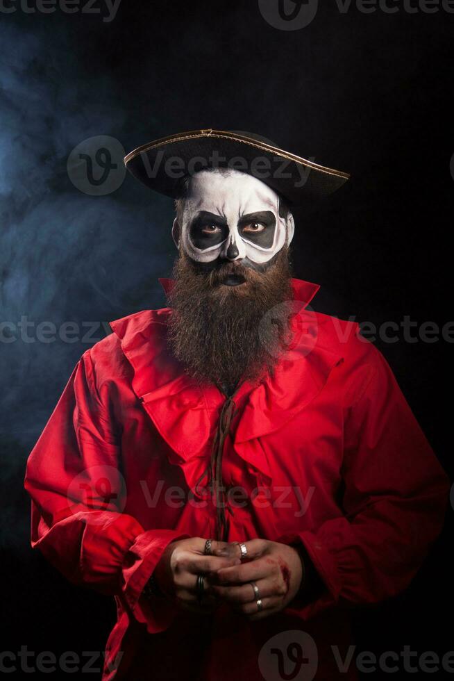 Actor wearing a pirate costume for halloween over black background. photo