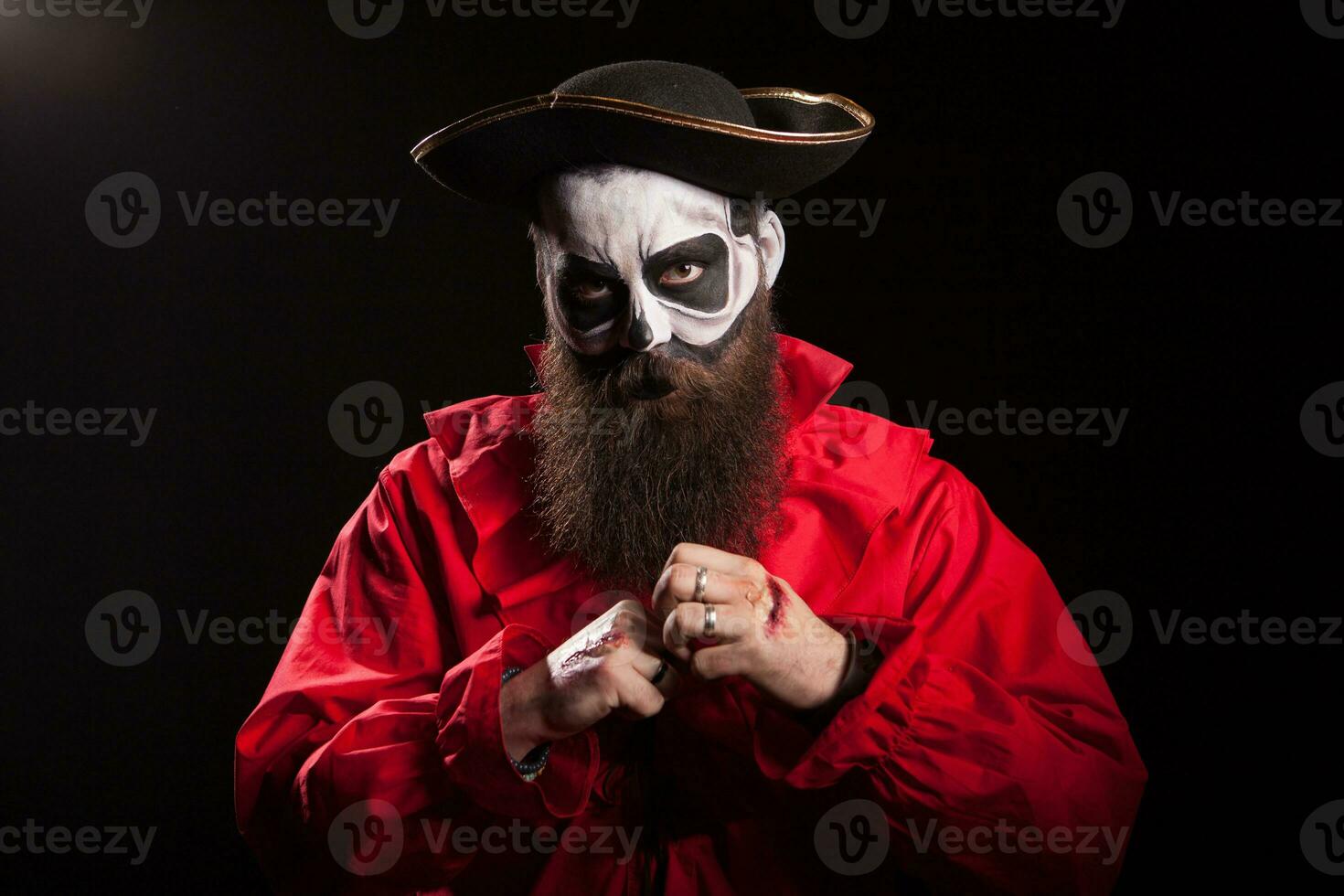 Bearded man disguised as a dangerous pirate over black background. photo