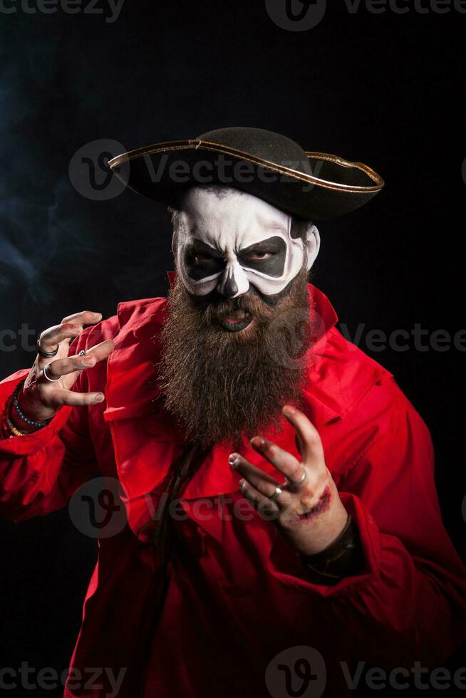 Actor with long beard and hat dressed up like a pirate over black background. Halloween costume. photo