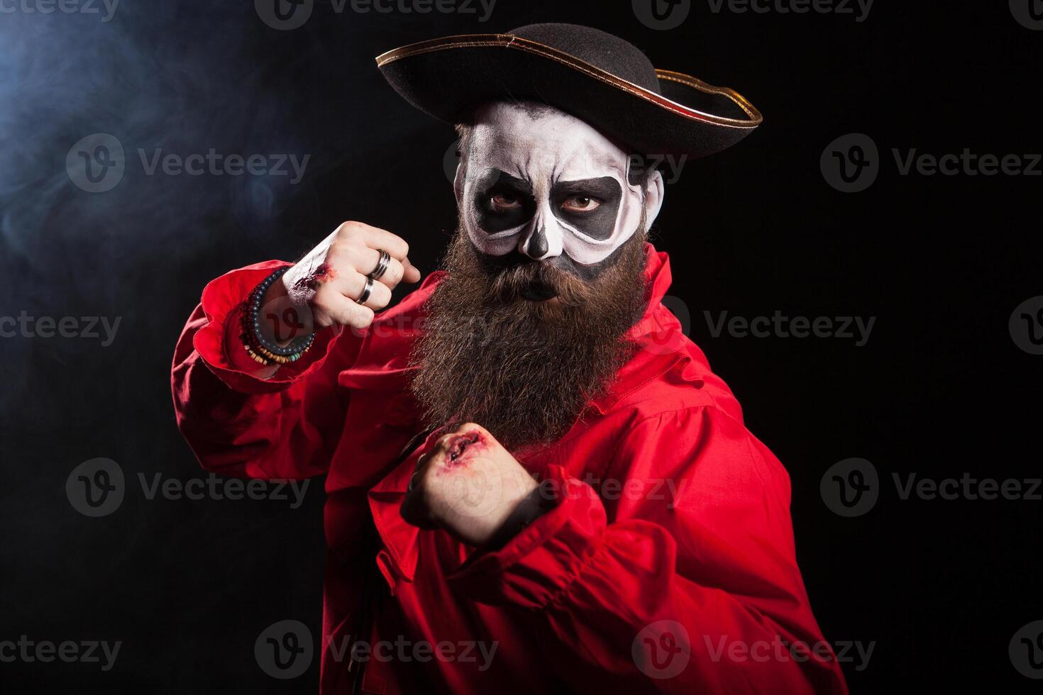 Scary pirate with fists up isolated over black background.Spooky man. photo