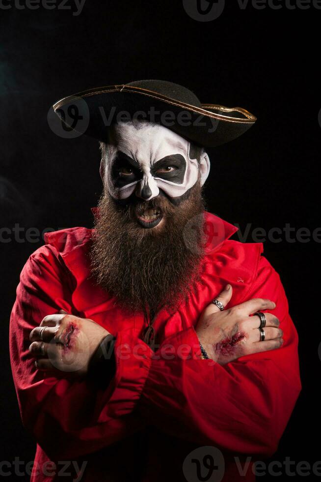 mal barbado pirata con escalofriante maquillaje para Víspera de Todos los Santos terminado negro antecedentes. foto
