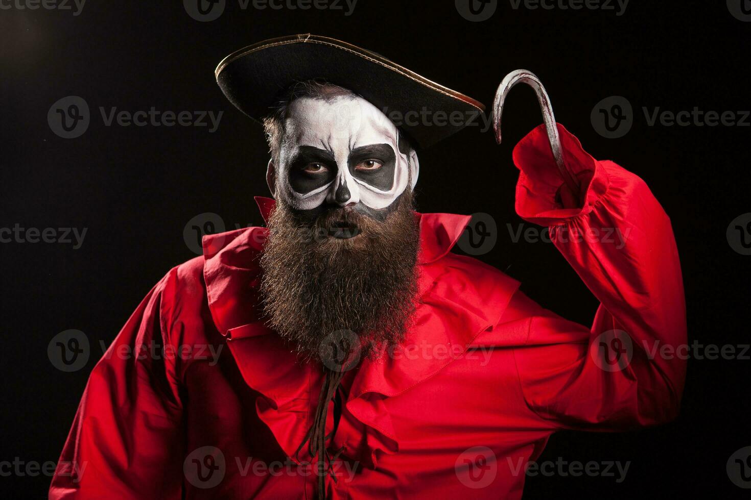 Crazy and dangerous pirate with a hook over black background. Halloween outfit. photo