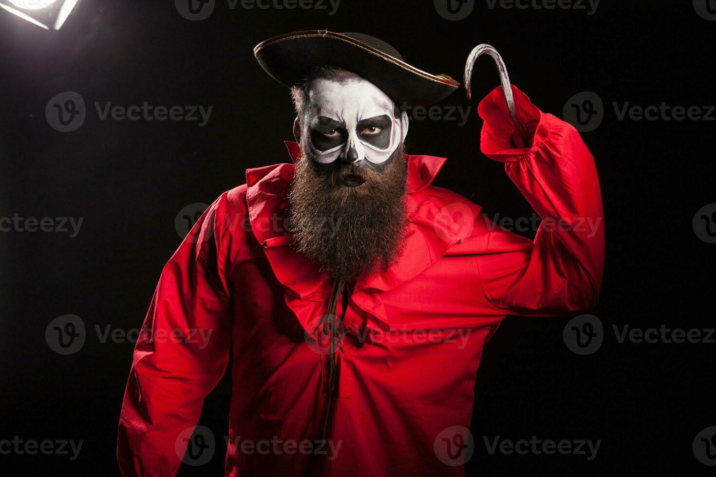 Scary pirate with a hook and long beard over black background. Halloween outfit. photo