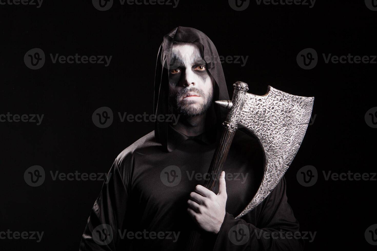 Evil grim reaper with an axe over black background for halloween. photo