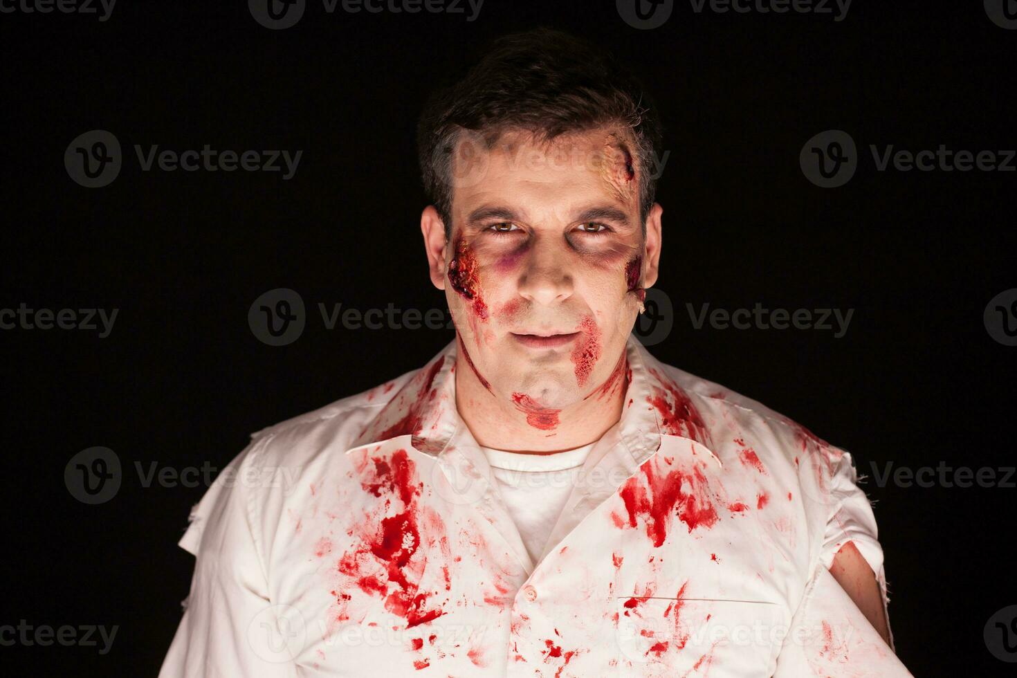 Man dressed up like a zombie for halloween over black background. photo