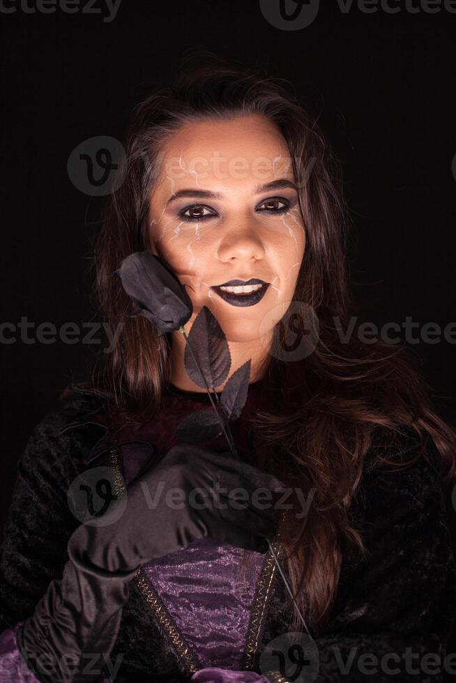 Witch with an evil face over black background . Halloween costume. photo