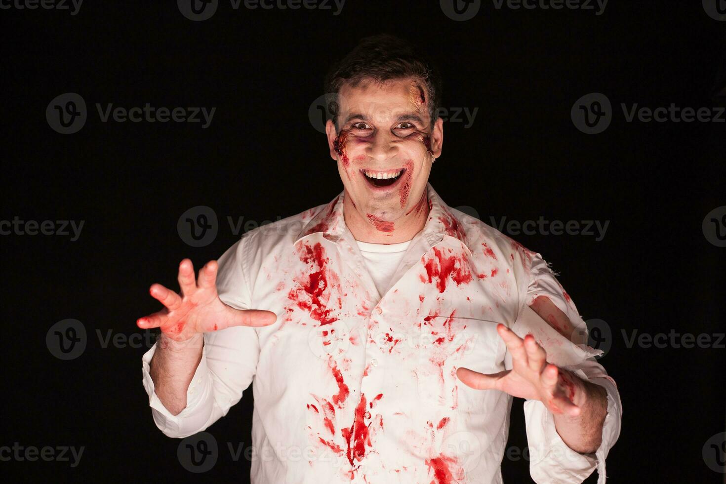 Violent and spooky man with blood on his body over black background. photo