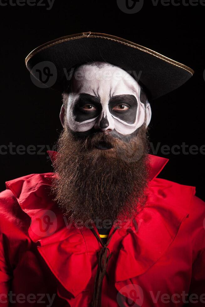 Handsome with a beard dressed up like dangerous pirate for halloween isolated on black background. photo