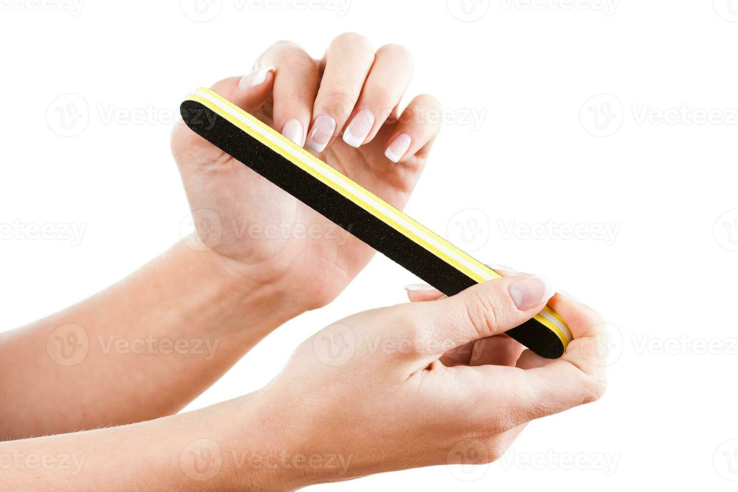 Close up of woman hands using nail file photo