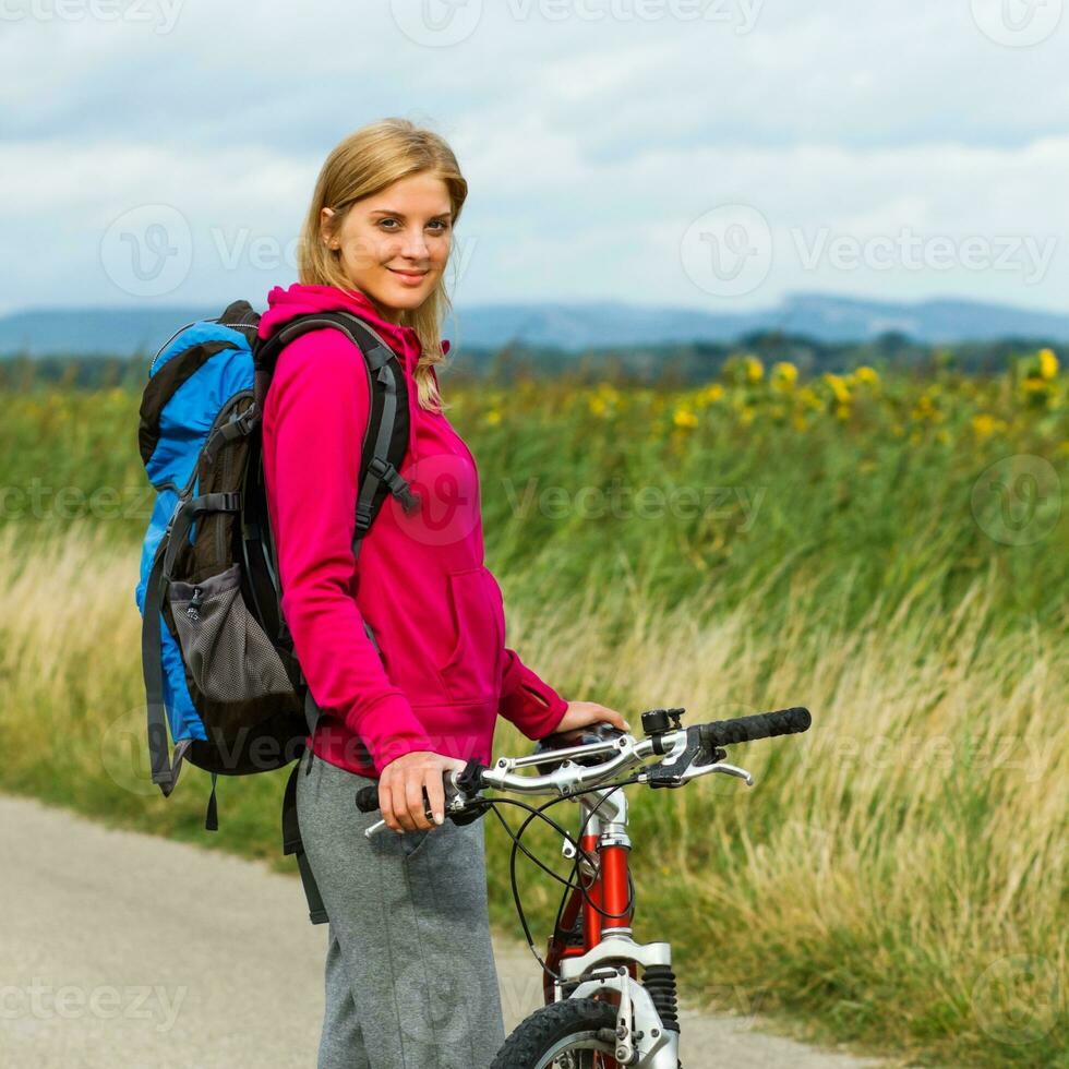 Woman hiker  with a bike photo