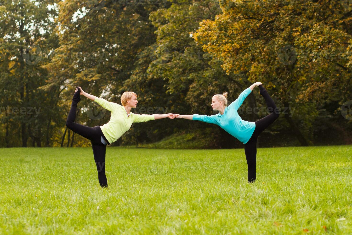 Two woman doing yoga in nature. photo
