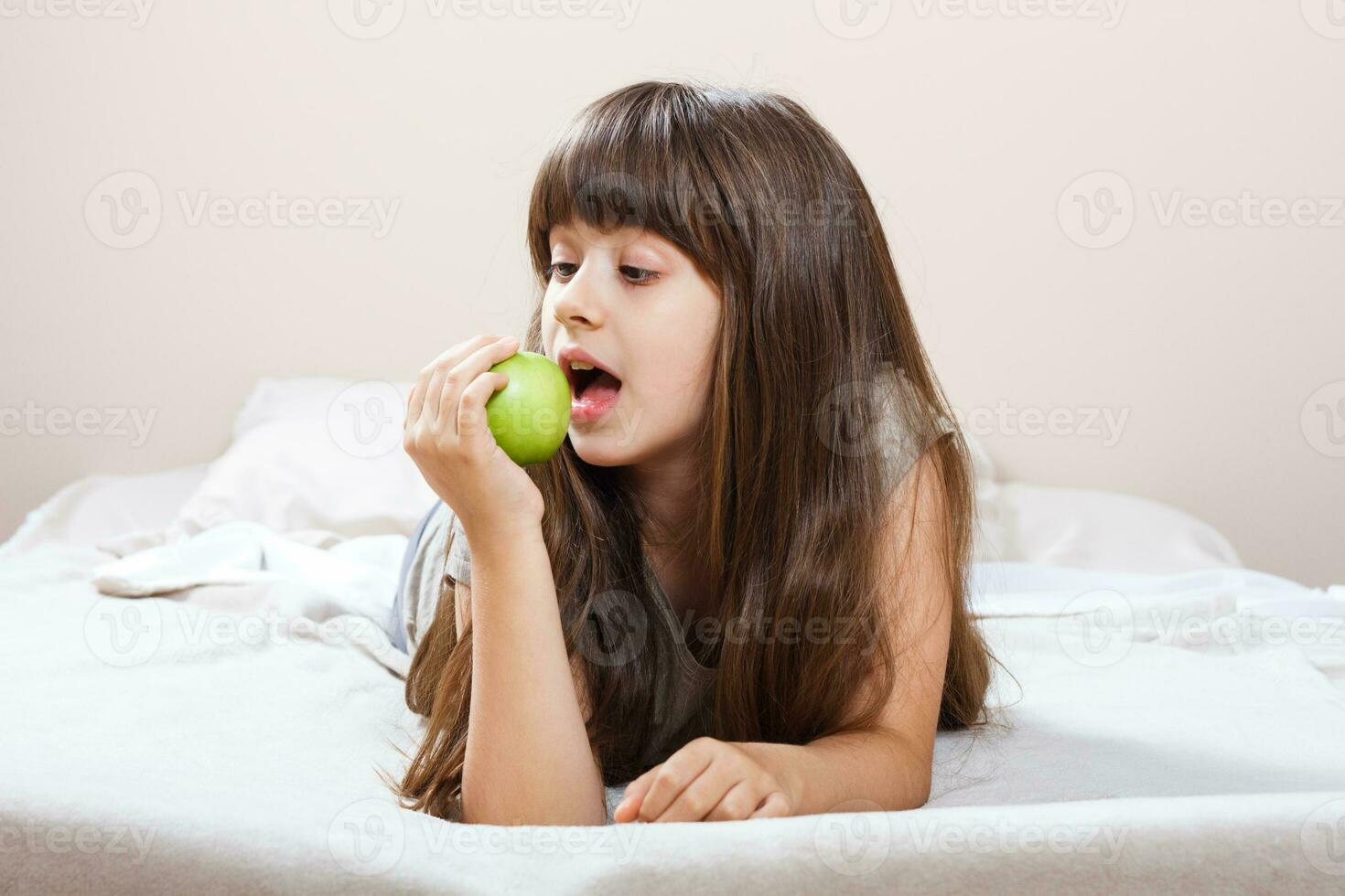 pequeño niña comiendo manzana foto